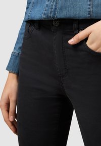 Svarta denimjeans med en slim fit, som har en klassisk midja, framsidiga fickor och minimal hårdvara. Slät textur med lätt stretch.