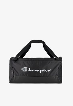 Borsa da viaggio nera in tela con manici rinforzati neri, chiusura con zip e tasca laterale in rete. Presenta un grande logo bianco "Champion". Materiale resistente.