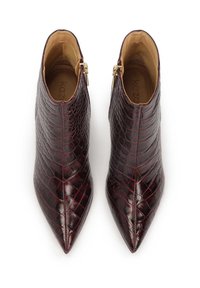 Botas de tobillo burdeos hechas de cuero sintético texturizado, con punta afilada y cremalleras laterales para el cierre. Forro interior suave.