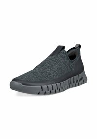 Kengät ilman nauhoja tummanharmaana, jossa on teksturoitu kangasylhä ja joustava kumipohja, jossa on sahalaitakuviota. Kantapäässä vetolenkkini, joka helpottaa pukemista.