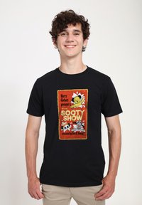 Černé bavlněné tričko s barevnou grafikou "The Sooty Show", zobrazující medvěda, psa a pandu, orámované červeným a žlutým designem.