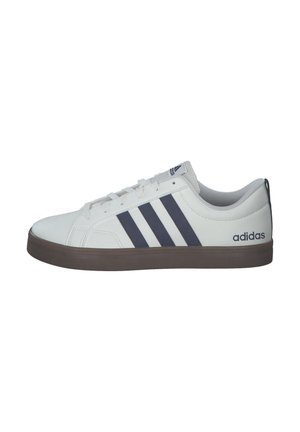 Zapatilla deportiva blanca con rayas azul marino, suela de goma, puntera redonda y diseño con cordones. Presenta el logo "adidas" en el lado.