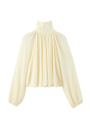 Blusa de color crema con mangas largas, cuello alto, tejido fruncido en el cuello y las mangas, y silueta ancha y fluida.