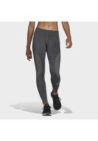 I leggings grigi con prestazioni presentano un design aderente, una texture liscia e dettagli decorativi sui lati. Completati con un logo sulla parte bassa della gamba.