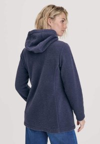 Marineblauwe fleece hoodie met een zachte textuur, voorzien van een capuchon, lange mouwen en een ontspannen pasvorm die tot op de heup reikt.