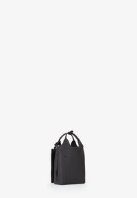 Borsa tote in pelle nera texturizzata con due manici e apertura superiore, in piedi su uno sfondo bianco.
