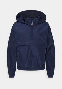 Granatowa kurtka typu windbreaker z półzamkiem, regulowanym kapturem, elastycznymi mankietami i haftowanym logiem "TOMMY HILFIGER" z przodu. Lekki materiał.