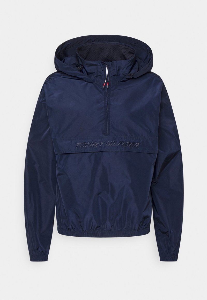 Granatowa kurtka typu windbreaker z półzamkiem, regulowanym kapturem, elastycznymi mankietami i haftowanym logiem "TOMMY HILFIGER" z przodu. Lekki materiał.