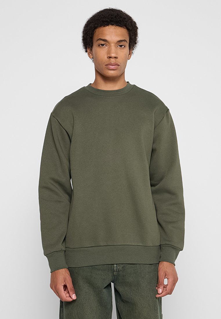 Olijfgroene sweatshirt met lange mouwen, geribbelde ronde halslijn en mouwmanchetten. Gemaakt van zacht materiaal met een relaxte pasvorm. Geen merkbare patronen.