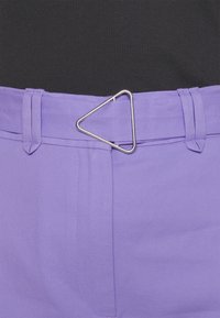 Purple pants with a smooth texture, featuring a triangular silver metal clip belt buckle and belt loops. Stitched details visible on fabric.