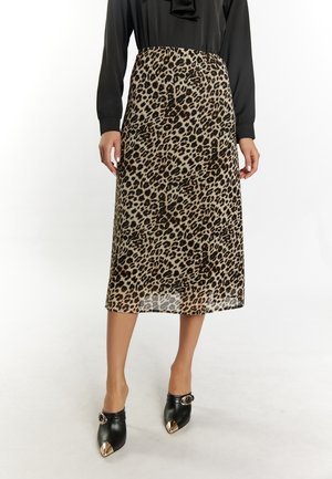 Midi sukně s leopardím vzorem a průhlednou texturou, s černým elastickým pasem a v kombinaci s černými muly s metalickými akcenty.