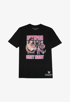 Schwarzes Baumwoll-T-Shirt mit einem grafischen Druck des Wrestlers Bret Hart, mit pinkem Text "HITMAN" und mehreren kreisförmigen Bildern von Hart.