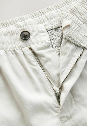 Heledad värviga lühikesed püksid, millel on elastne vöökoht, tõmbluku sulgemine ja nööbi kinnitamine. Sisemine vooder sisaldab väikest lillemustriga. 