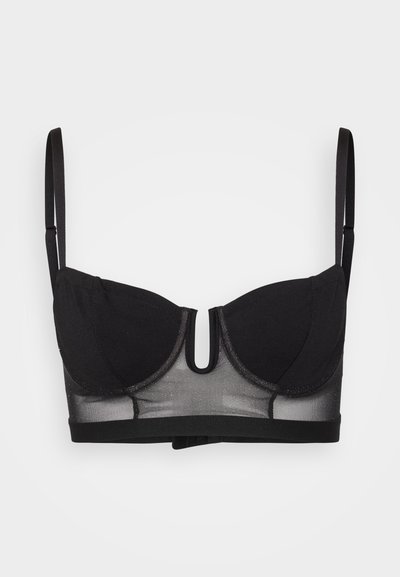 Zwarte beha met een gaas onderband en gevoerde cups. Beschikt over verstelbare straps en een uitsnijding in het midden. Gladde textuur met een subtiele glans.