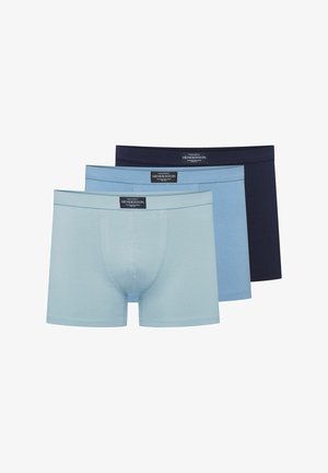 Graue Baumwoll-Boxershorts mit angepasstem Design, kontrastierendem Bund und mittlerem Schnitt, präsentiert an einem stehenden männlichen Modell.