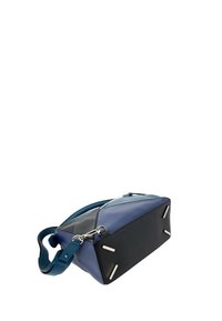 Sac à main rectangulaire avec panneaux bleus et noirs, quincaillerie argentée et bandoulière bleue réglable sur fond blanc.