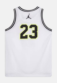 Valkoinen verkkokangaspaidassa on mustia ja neonkeltaisia yksityiskohtia, takana on selvästi näkyvissä numero "23" ja Jumpman-logo sen yläpuolella.