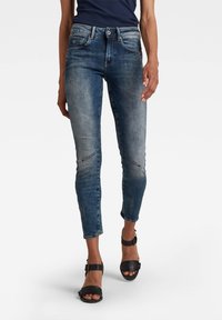 Getailleerde, cropped jeans van denim in verschillende blauwtinten met subtiele vervaging, vijf zakken en een rits met knoopsluiting.