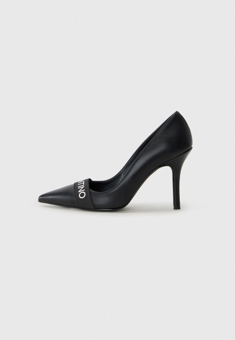 Zapato de tacón alto negro de piel, con puntera afilada y una correa con la marca "VALENTINO" en texto blanco. Textura suave.