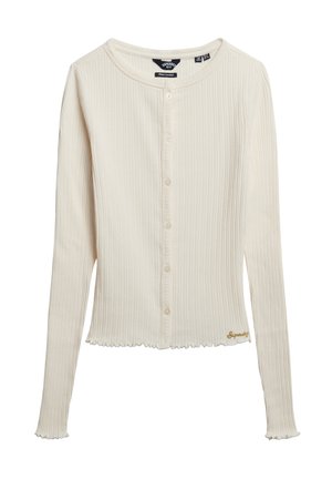 Cremefarbener, gerippter Langarm-Cardigan mit Knöpfen auf der Vorderseite und kleinem goldfarbenem "Superdry"-Logo nahe dem Saum auf einem weißen Hintergrund.