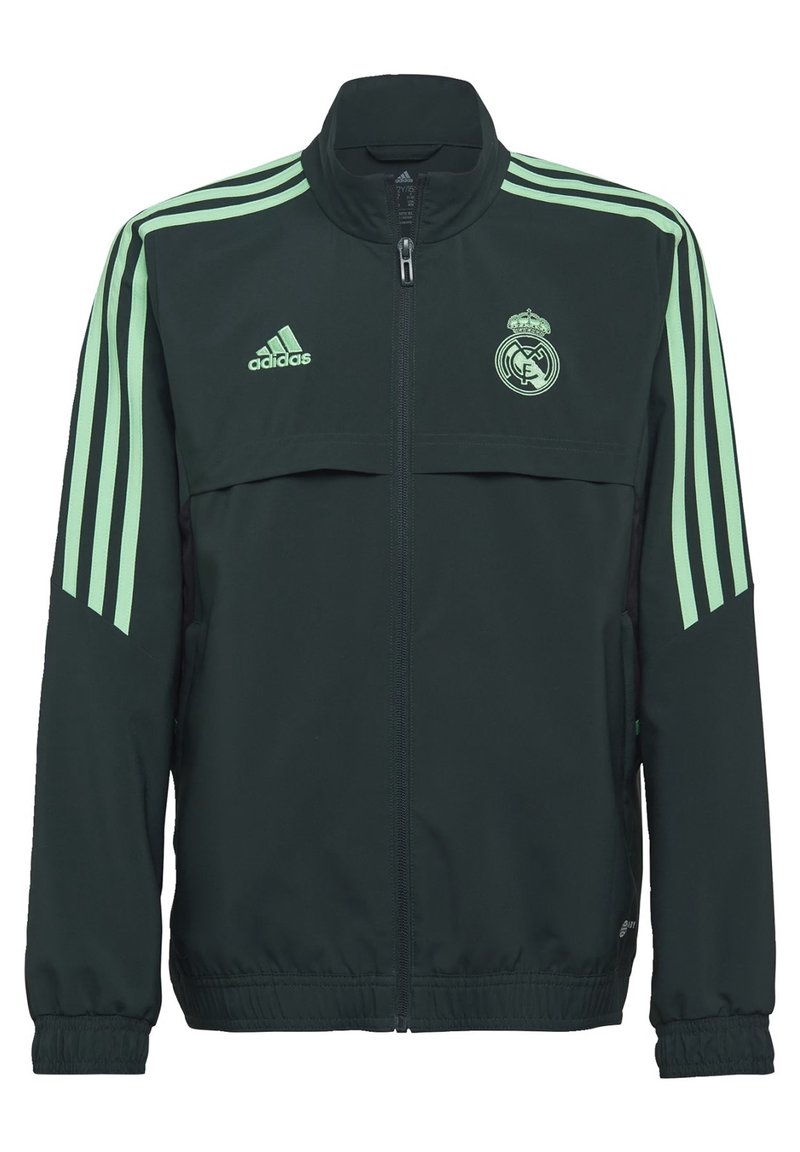 Chaqueta verde oscura con acentos en verde claro y tres franjas en cada manga. Cuenta con un cuello alto y el logo del Real Madrid en el pecho.