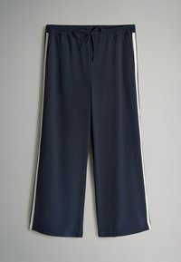 Námornícke modré športové nohavice s bielymi bočnými pruhmi, elastickým pásom a šnúrkou na stiahnutie. Voľný strih a ľahká tkanina pre pohodlie.