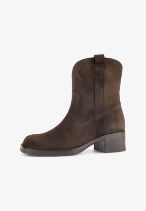 Brauner Wildleder-Stiefelette mit niedrigem Blockabsatz und Zuglasche, Seitenansicht vor weißem Hintergrund.