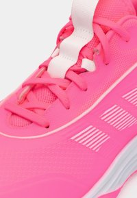 Scarpa sportiva di un rosa acceso con materiale a rete, lacci bianchi piatti e dettaglio a strisce sul lato. Design ad alto contrasto con imbottitura.