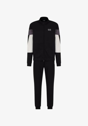 Tuta sportiva nera con giacca zip-up caratterizzata da pannelli bianchi e grigi. I pantaloni hanno un design affusolato con polsini elasticizzati.