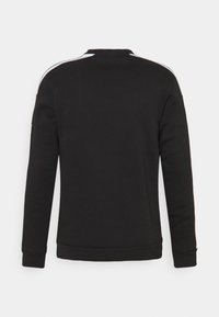 Svart hettegenser med lange ermer, rund hals og hvite striper langs skuldrene. Mykt materiale, ribbestrikkede mansjetter og nederkant.