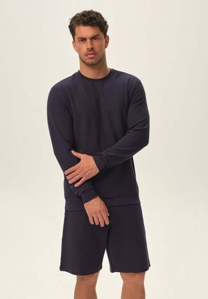 Navy blue long-sleeve shirt made of textured fabric paired with matching shorts, featuring a fitted design and ribbed cuffs and hem.