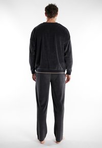 Grijze fleece loungewear set met een ontspannen pasvorm, een pullover met een ronde hals en bijpassende broek met een elastische tailleband.