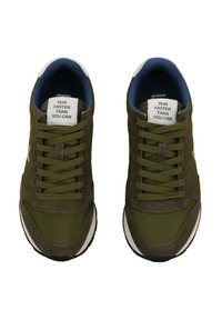 Green running shoes with a mix of suede and fabric, featuring a white accent, round laces, and a blue inner lining with a motivational label.