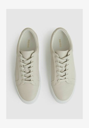 Kerged beige nahkist tenniset tekstuuriga viimistlusega, millel on kuus aukku, siledad paelad ja valge kummist tald. Siseosa kuldsete brändingutega.