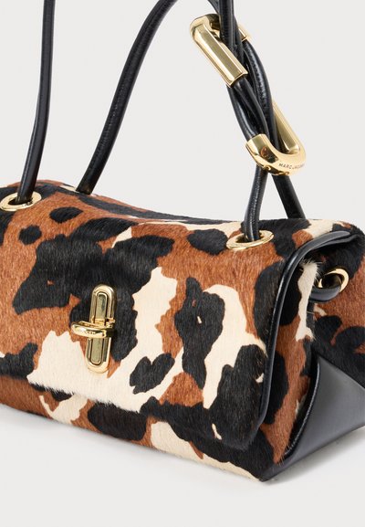 Hnedá a čierna kabelka s bodkami, vyrobená z textúrovanej kožušiny s čiernym koženým základom, vybavená zlatým kovaním a dvojitými rúčkami.