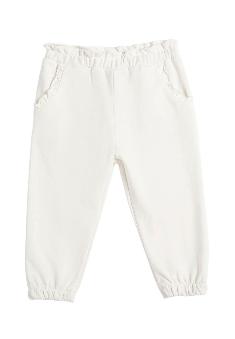 Pantalones de forro polar blancos con cintura elástica y borde con volantes. Cuenta con dos bolsillos laterales y puños elásticos en el tobillo. Textura suave.