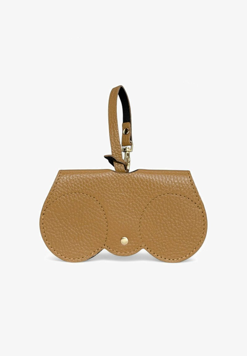 Pochette en cuir tan avec deux compartiments circulaires, texture lisse, fermeture à bouton-pression en métal, et une sangle pour le poignet. Présente un design minimaliste.