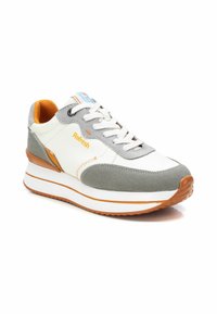 Sneaker bianca e grigia con un design testurizzato, dettagli arancioni e una suola intermedia bianca. Presenta lacci rotondi e un colletto imbottito.
