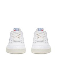 Bílé tenisky s koženým svrškem, texturovaným polstrováním a perforovanou špičkou. Šněrovací design s bledě zbarvenou gumovou podrážkou a modrým logem.