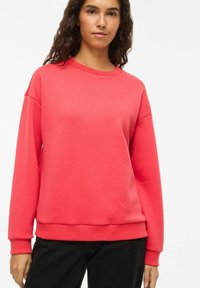 Sweat-shirt corail en mélange de coton doux, doté d'un col ras du cou classique, d'épaules tombantes, et de poignets et ourlet côtelés. Design simple.