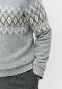 Jasnoszara sweter z dzianiny z geometrycznym wzorem w diamenty i zygzaki w kolorze kremowym i brązowym, z prążkowanymi mankietami i dołem.