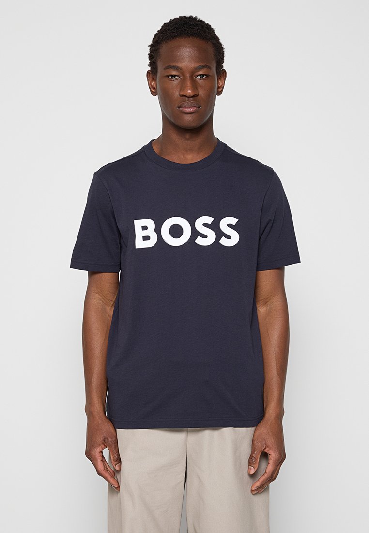 T-shirt bleu marine à manches courtes en coton, arborant un grand logo blanc « BOSS » sur la poitrine, avec un col rond classique.