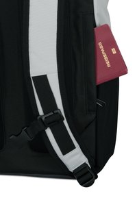 Fekete-fehér hátizsák, texturált felülettel, kiemelkedő csattal, és egy látható bordó útlevéllel, amelyen a "REISEPASS" felirat olvasható.