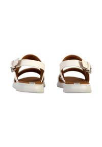 Sandalias blancas con correas ajustables, parte superior lisa y plantilla en tono bronceado. Presenta una suela plana de goma texturizada para mayor agarre.