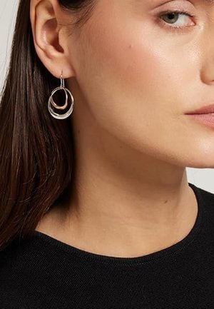 Orecchini a cerchio in argento e oro rosa con design circolare a strati, caratterizzati da una finitura lucida e una sottile texture intrecciata.