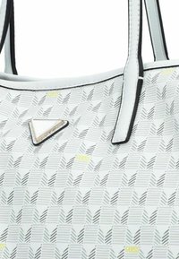 Borsa bianca con un motivo geometrico, caratterizzata da un accento triangolare in argento e rifiniture nere. Texture liscia con materiale resistente.