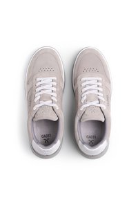 Baskets en suède gris clair avec des lacets blancs, détails perforés sur le bout, et branding subtil. Accents lisses sur le talon et semelle en caoutchouc.