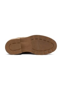 Suela de goma marrón con un patrón de pisada texturizado y acantilados distintivos. Sección suave cerca del talón, diseñada para ofrecer agarre y durabilidad.