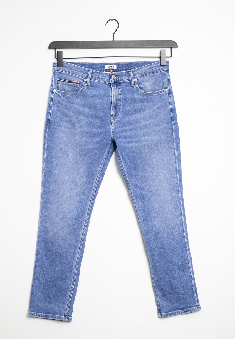 Helle blaue Denim-Jeans, die an einem schwarzen Kleiderbügel vor einem weißen Hintergrund hängen, mit sichtbaren Fronttaschen und Knopfverschluss.