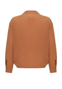 Braune Bluse mit langen Ärmeln und Kragen, glatte Textur, seitliche Schlitze an den Ärmelbündchen und lockere Passform, die ein minimalistisches Design präsentiert.